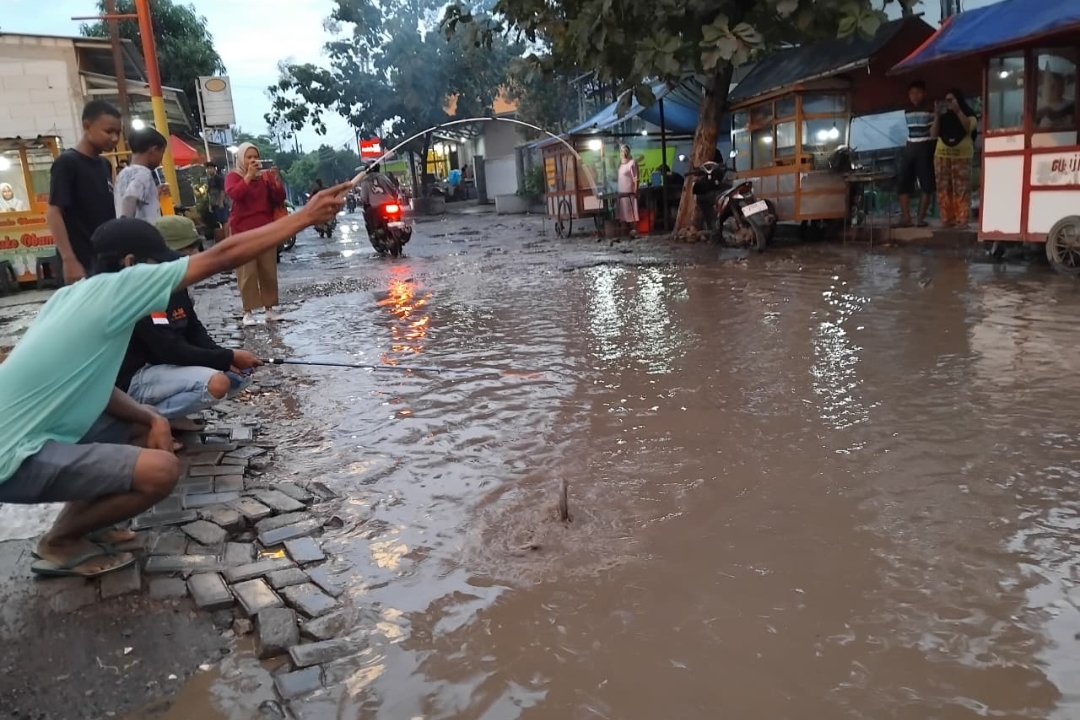 Sindir Pemkab Cirebon Tak Segera Perbaiki Jalan Rusak, Warga Kaliwulu Plered Mancing Ikan di Kubangan