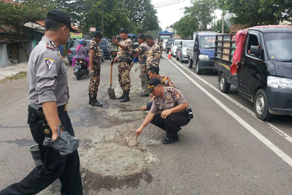 Polisi Bersama FKPPI Tambal Lubang Jalan Kalijaga Kota Cirebon