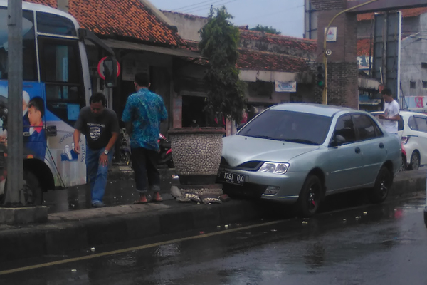 Mobil Sedan Oleng, Tabrak Pot, Lalu Nyangkut di Median Jalan