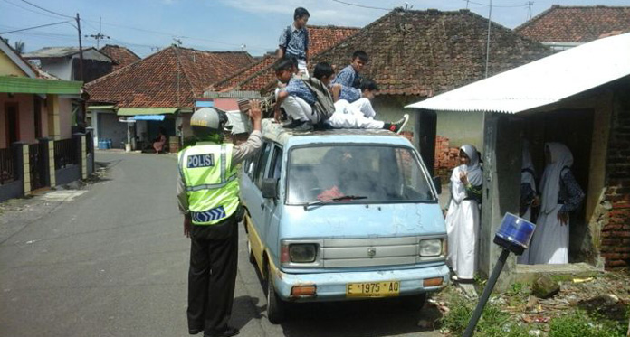 Berbahaya, Polisi Turunkan Sejumlah Siswa SMP yang Naik Atap Angkot