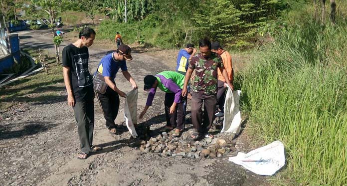 Siswa Tambal Jalan Ciniru yang Rusak Berlubang