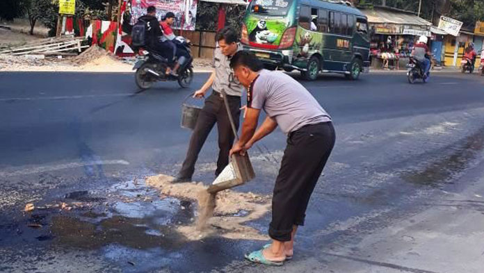 Bahayakan Pengendara, Polsek Ciwaringin Bersihkan Ceceran Oli di Jalan Raya