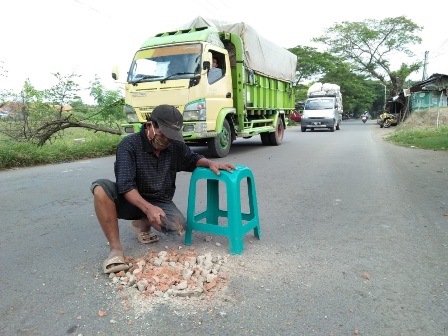 Banyak Kecelakaan, Seorang Kakek Inisiatif  Tambal Jalan Berlubang