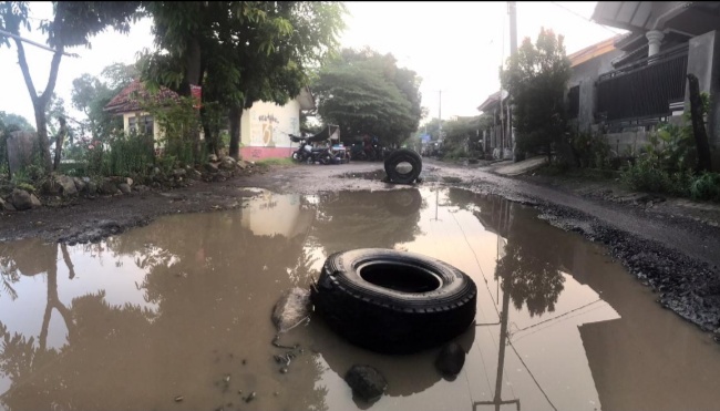 Jalan Ponpes Kempek Rusak Parah, Warga Pasang Ban Hindari Korban