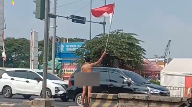 Viral! Pria Ini Pakai Popok Sambil Kibarkan Bendera di Jalanan